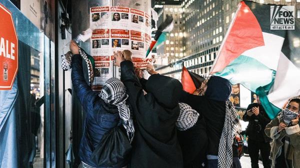Protesters tear down posters