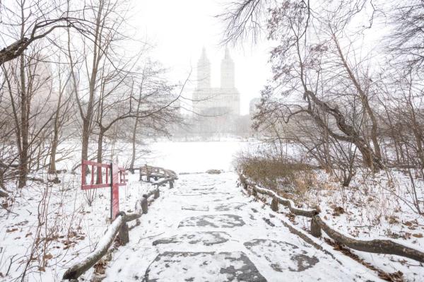 Central Park path and lake seen with some snow covering the ground.