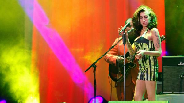 Amy Winehouse o<em></em>nstage in striped dress