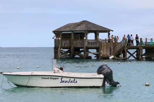 People gather on the resort pier after what police described as a fatal shark attack against a tourist at Sandals Royal Bahamian resort.