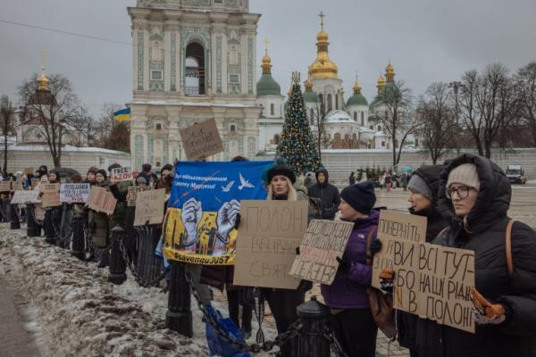 Family and friends of Ukrainian POWs call for a rapid priso<em></em>ner exchange with Russia. They are holding banners and standing in Saint Sophia Square