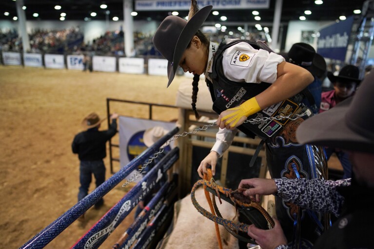 Najiah Knight prepares to ride a bull during the Junior World Finals rodeo, Thursday, Dec. 7, 2023, in Las Vegas. Najiah, a high school junior from small-town Oregon, is on a yearslong quest to become the first woman to compete at the top level of the Professio<em></em>nal Bull Riders tour. (AP Photo/John Locher)