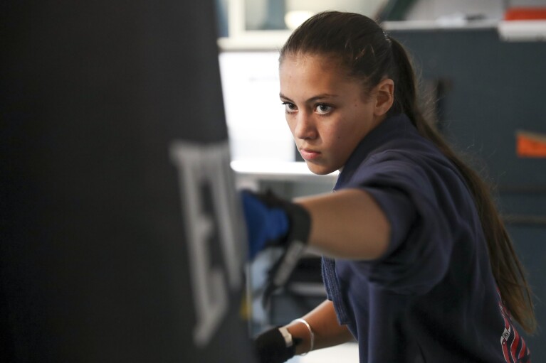 Najiah Knight boxes while working out in the garage at the family's home in Arlington, Ore., Wednesday, Oct. 18, 2023. Najiah, a high school junior from small-town Oregon, is on a yearslong quest to become the first woman to compete at the top level of the Professio<em></em>nal Bull Riders tour. (AP Photo/Amanda Loman)