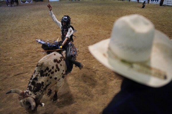 Najiah Knight competes during the Junior World Finals rodeo, Thursday, Dec. 7, 2023, in Las Vegas. Najiah, a high school junior from small-town Oregon, is on a yearslong quest to become the first woman to compete at the top level of the Professio<em></em>nal Bull Riders tour. (AP Photo/John Locher)