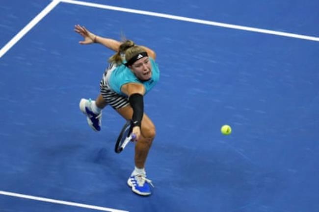 Karolina Muchová stretches to reach a ball.