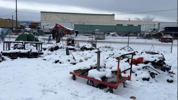 A burned sofa, a pile of burned refuse and what looks like a me<em></em>tal trolley are covered in a fresh layer of snow at the site of a tent fire a few days ago at the encampment. 