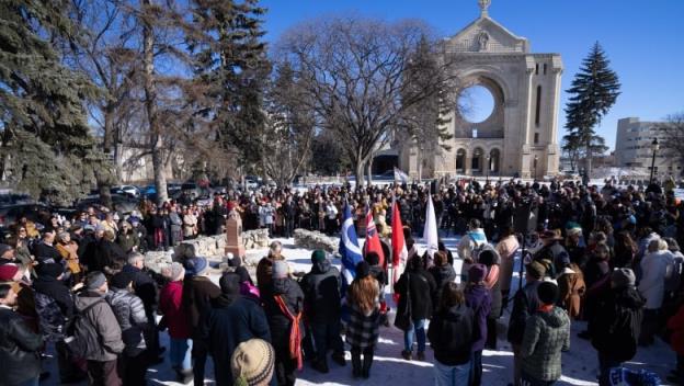 A crowd of people are seen gathered outside.